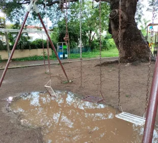 Zona de columpios inundada con juegos rotos