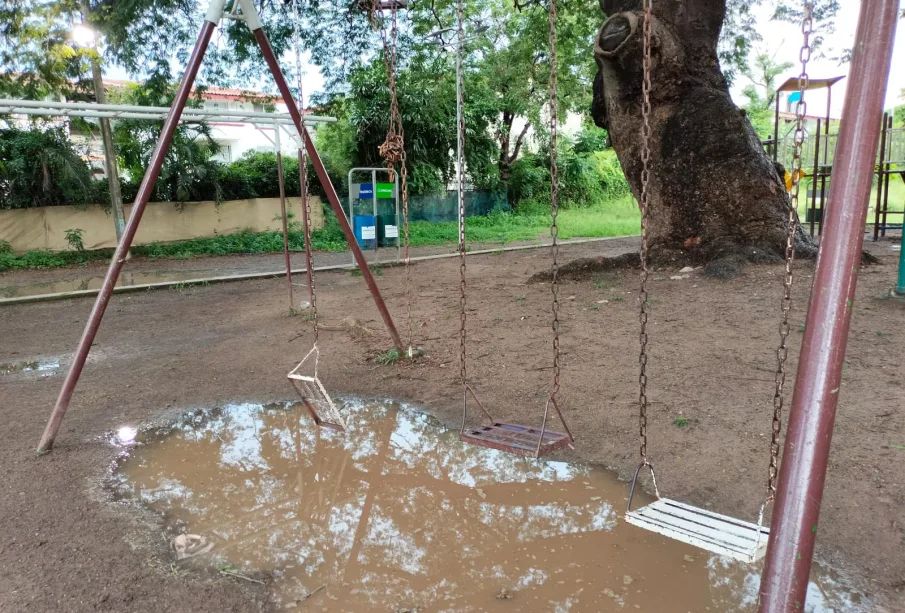 Zona de columpios inundada con juegos rotos