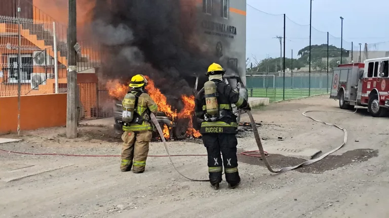 Bomberos sofocando llamas en auto