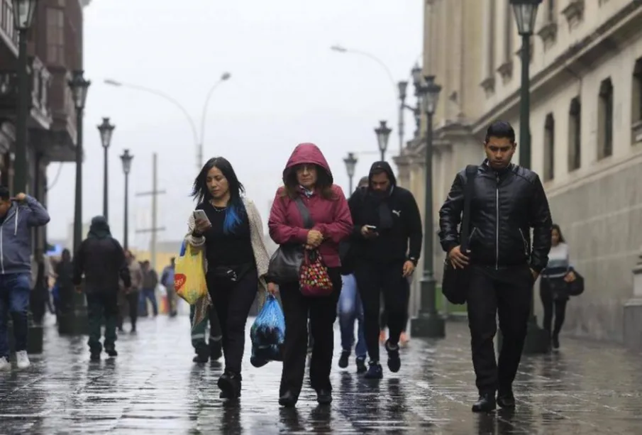 Personas caminando abrigadas por la calle