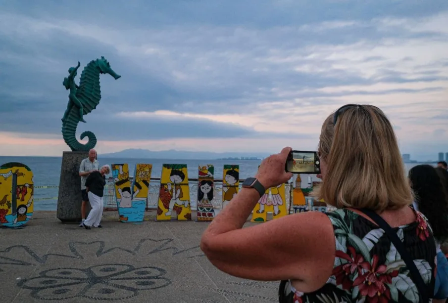 Turistas tomándose foto en el malecon de Puerto Vallarta