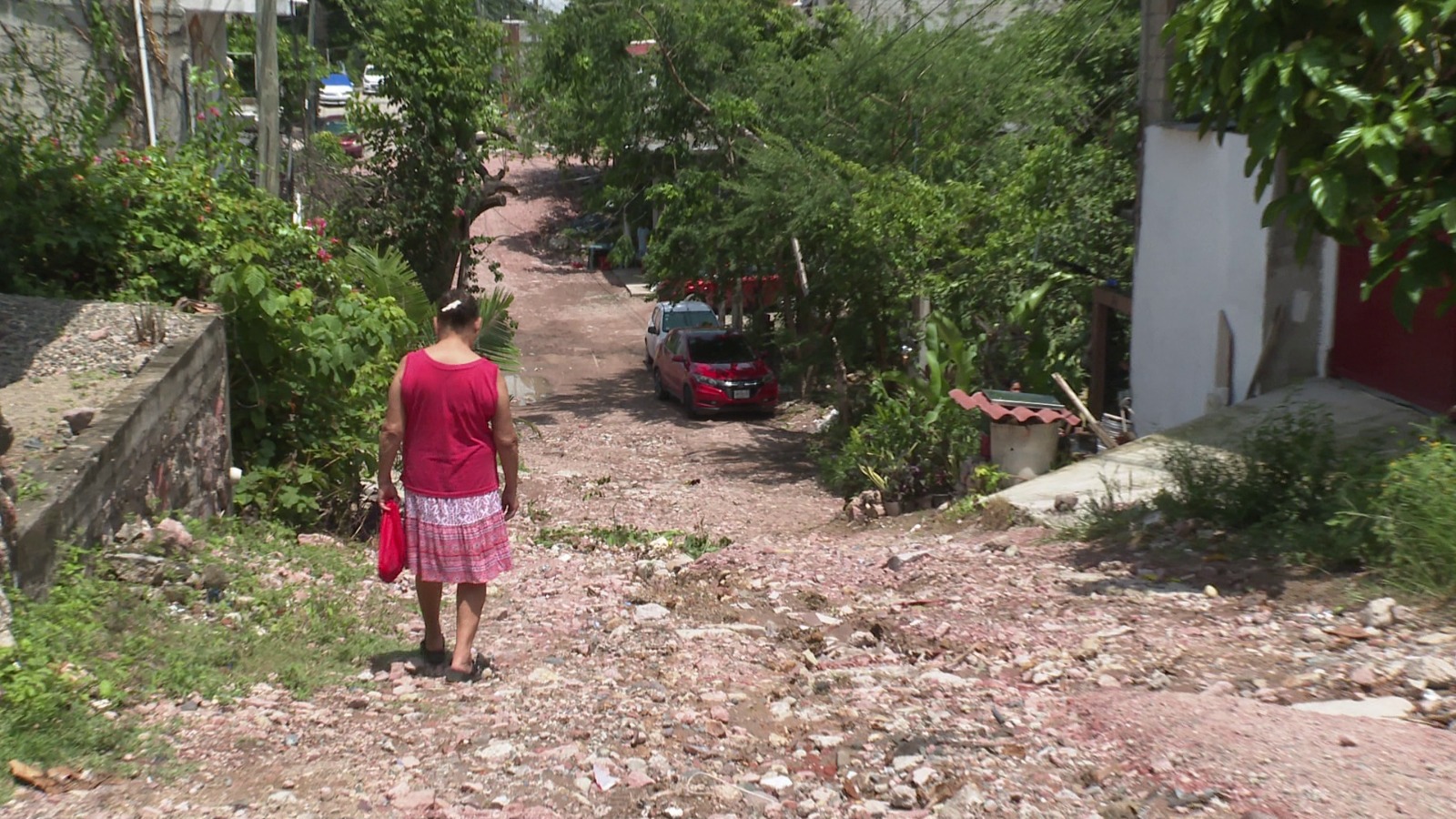 Mujer caminando sobre la calle Puerto de Manzanillo sin pavimentar