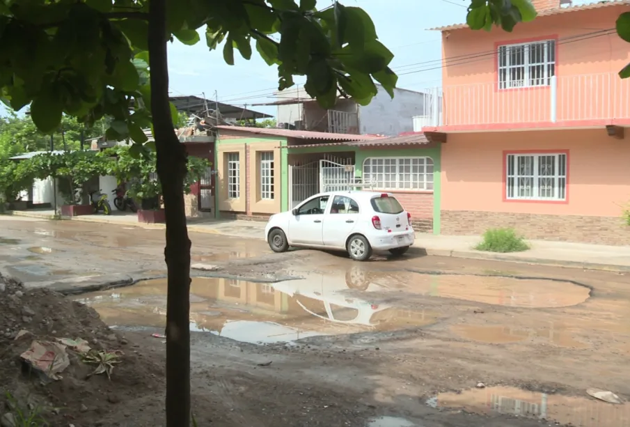 Gran bache cubierto de agua en calle avenida