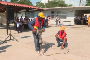Trabajadores haciendo perforación en piso de escuela