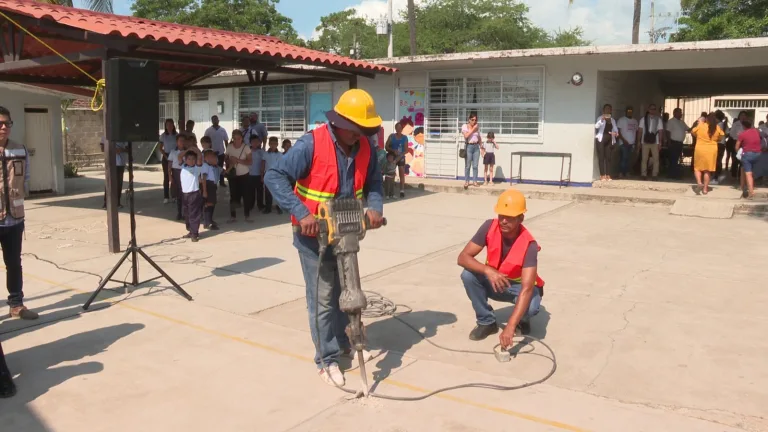 Trabajadores haciendo perforación en piso de escuela