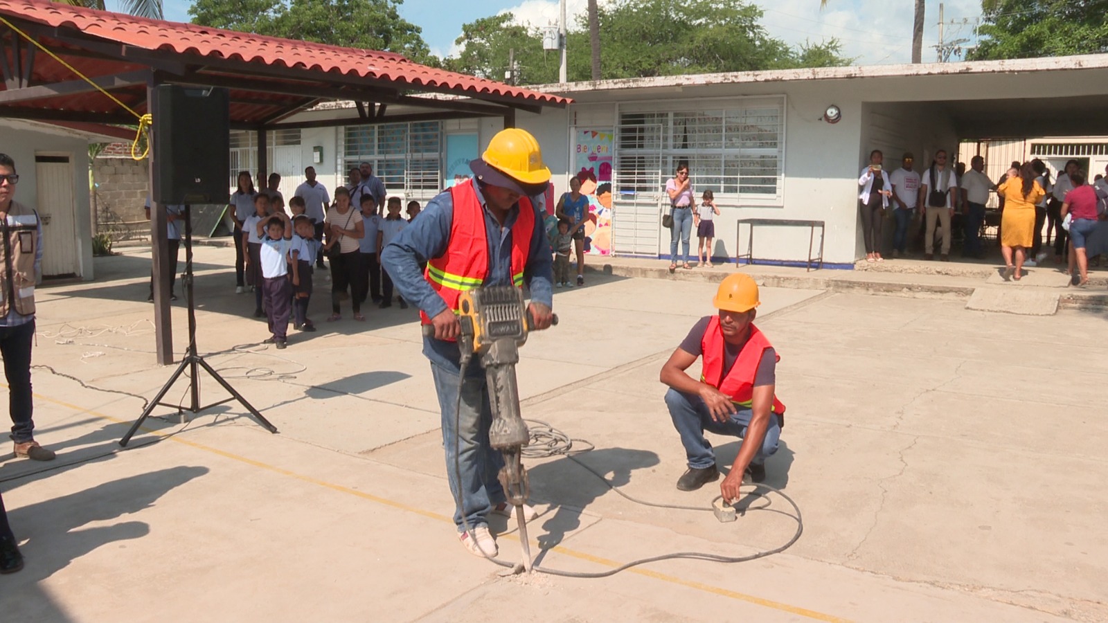 Trabajadores haciendo perforación en piso de escuela