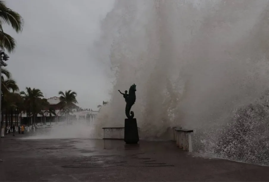 Olas golpeando a estatua en el malecón