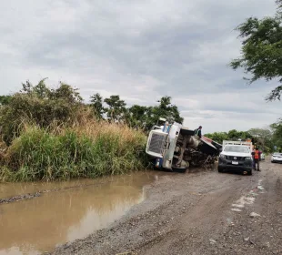 Camión de volteo volcado en camino