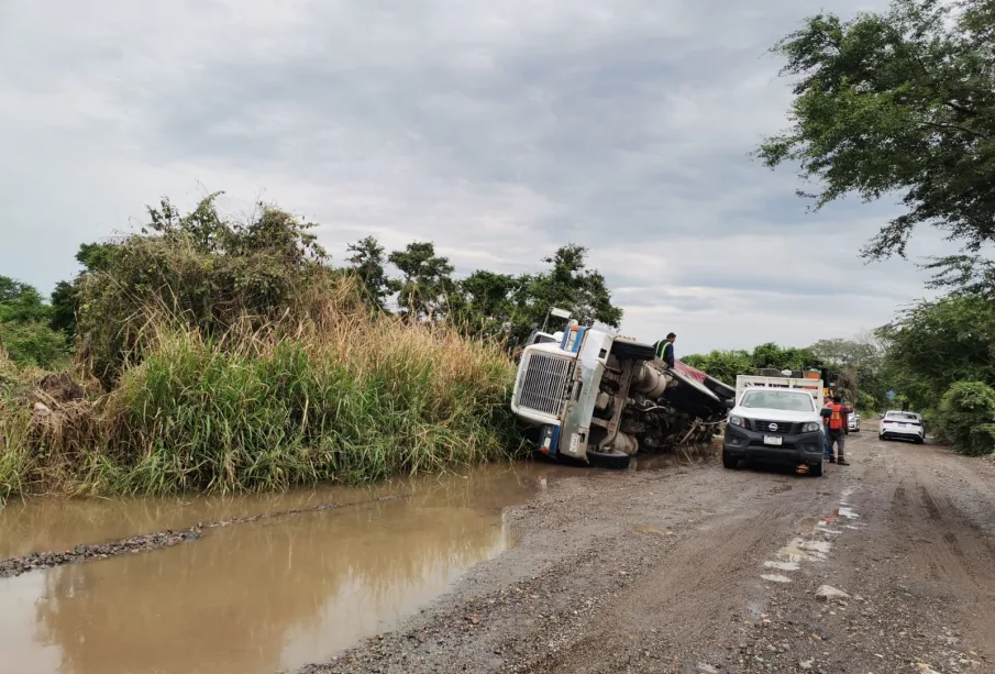 Camión de volteo volcado en camino