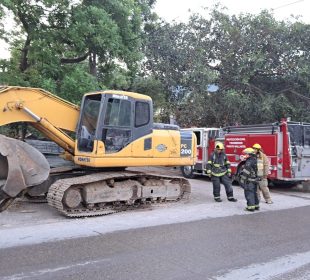 Bomberos junto a retroexcavadora que prendieron fuego