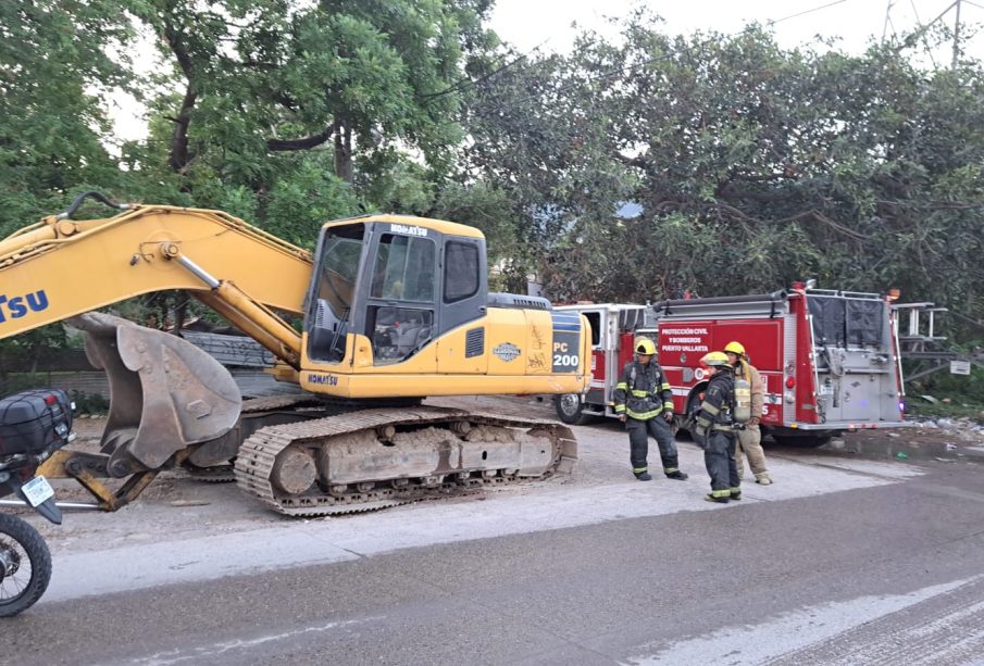 Bomberos junto a retroexcavadora que prendieron fuego