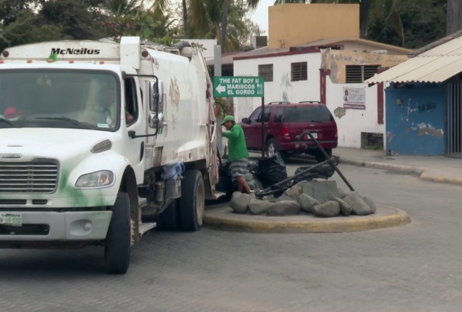 Camión de basura y trabajador recolectando