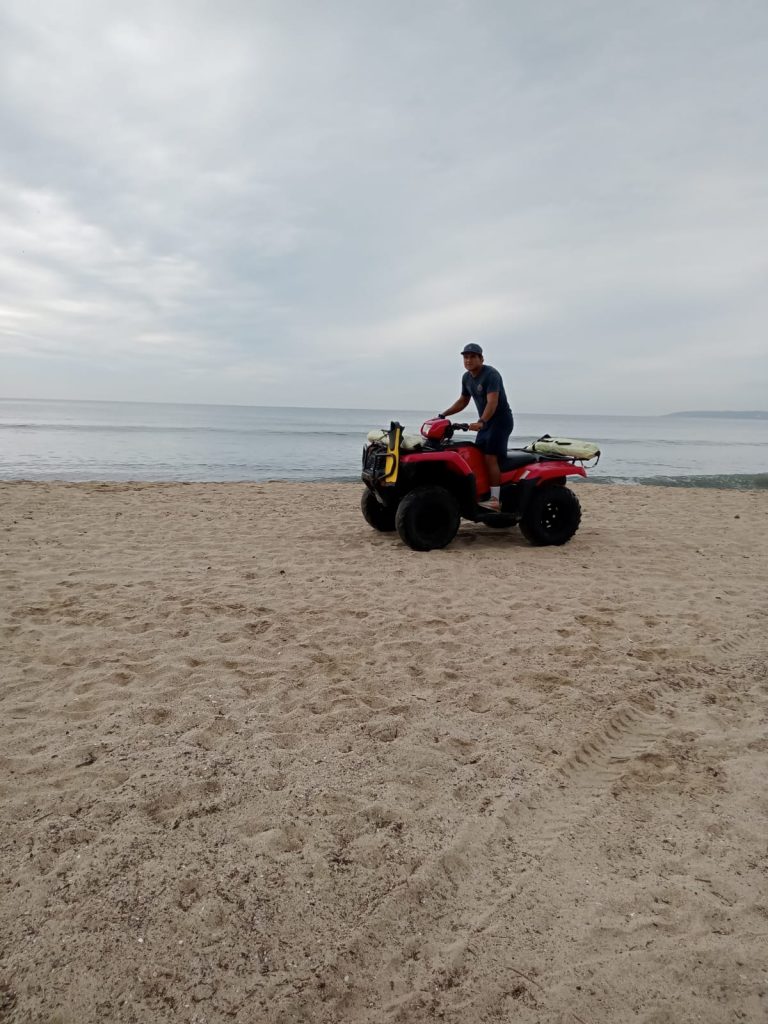 Personal recorriendo playa en moto por reporte de cocodrilo