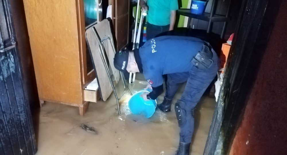 Policía ayudando a sacar agua de casa