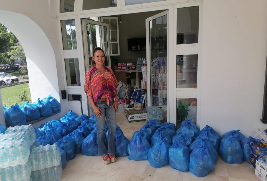 Yozozky Dinorah Cortés González junto a despensas recolectadas en centro de acopio