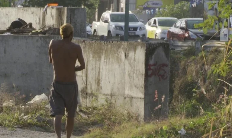 Hombre sin playera caminando por parque