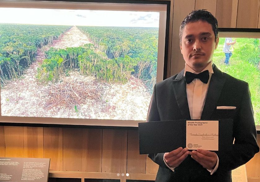 Fernando Constantino Martínez Belmar junto a fotografía de la deforestación del Tren Maya