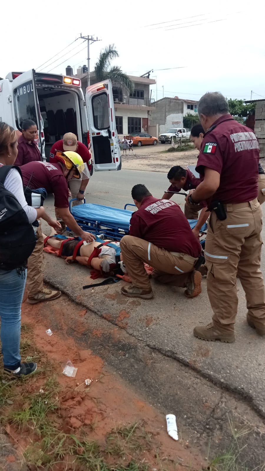 parámedicos de bomberos asegurando en camillla a atropellado