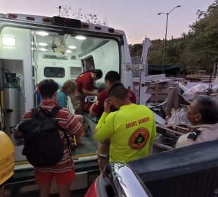 Paramédicos y personas junto a ambulancia