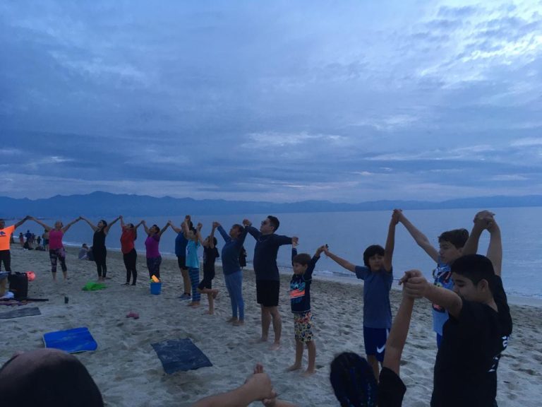 Adultos y niños participando de class de yoga