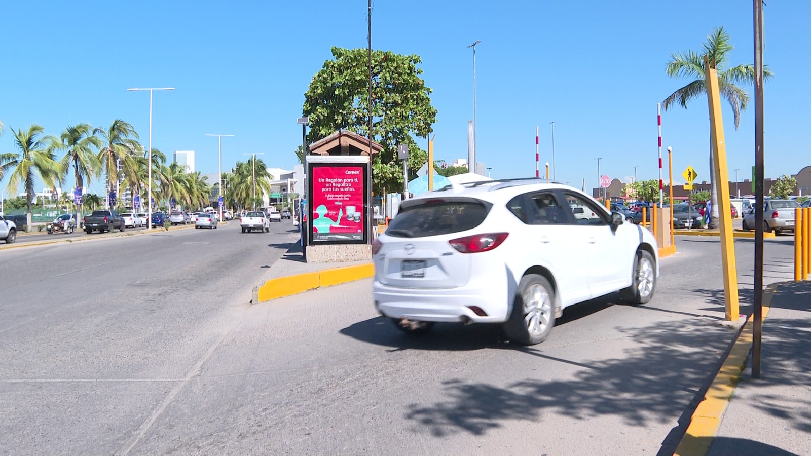 Auto blanco entrando al estacionamiento de Sams