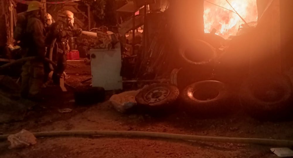 Bomberos sofocando incendio en chatarrera