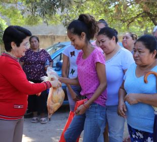 Presidenta del DIF entregando a familias pollos