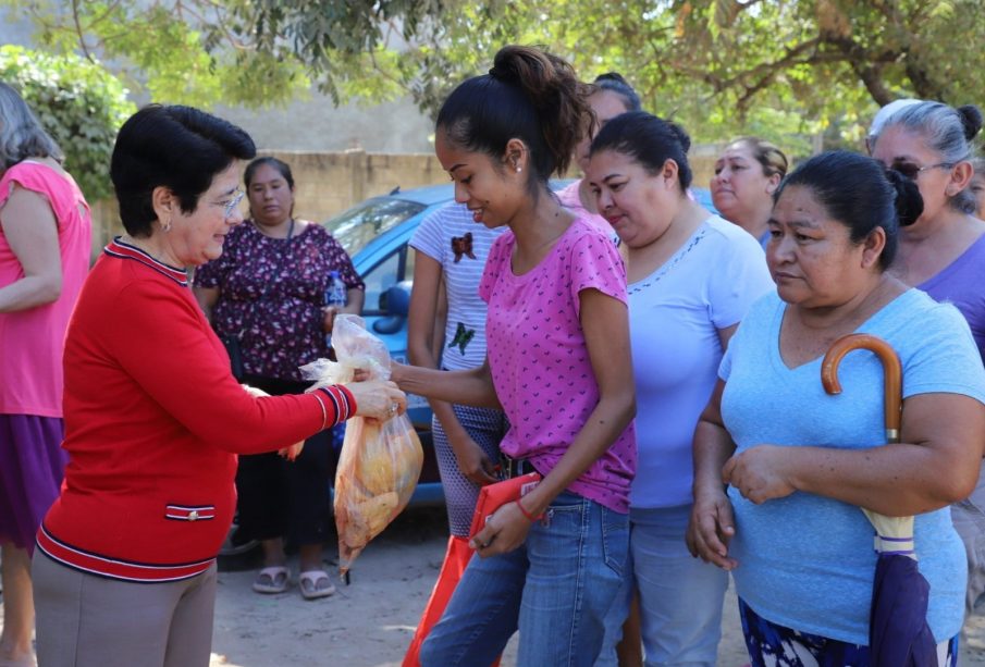 Presidenta del DIF entregando a familias pollos