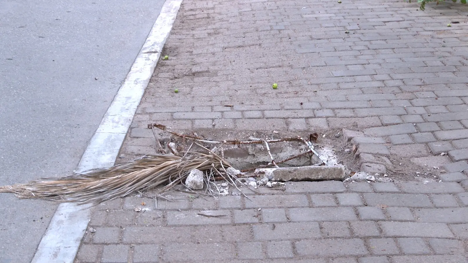 Registro abierto con basura en parque lineal
