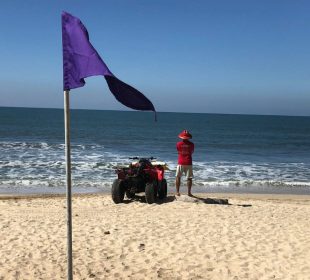 Bandera morada en playa de Bahía de Banderas