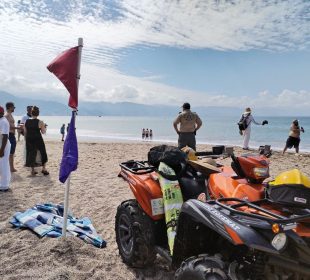 Bandera roja y morada en playa de Vallarta