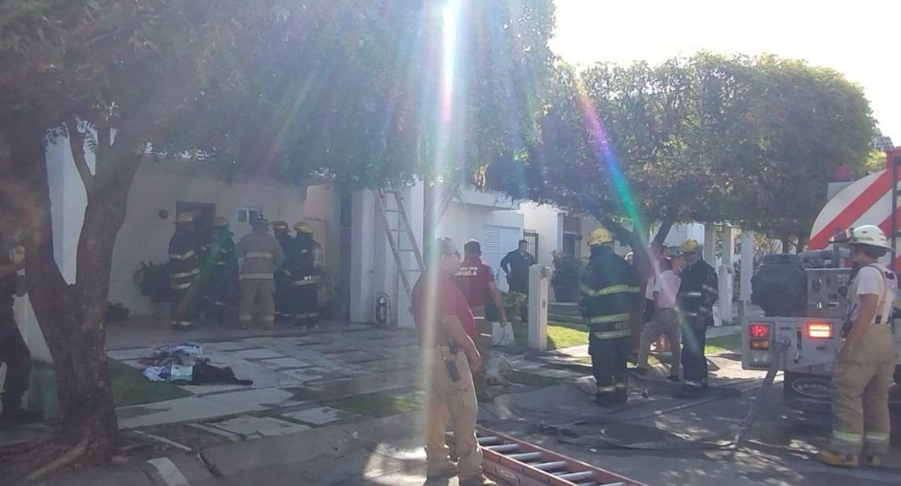 Bomberos entrando a casa incendiada