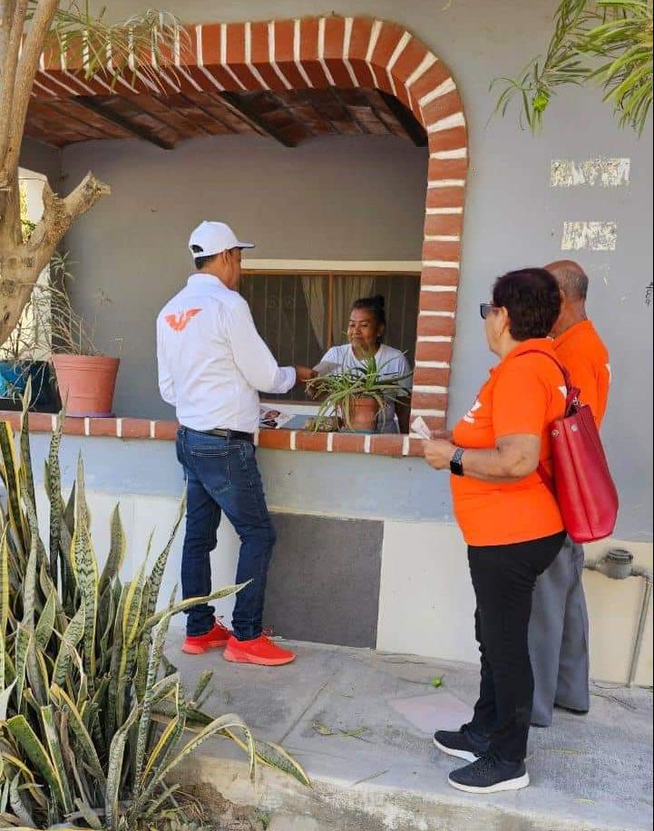 Ismael Duñalds platicando con una comerciante