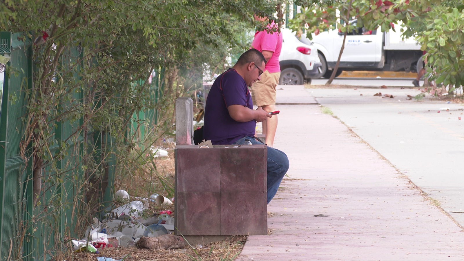 Persona sentada en banca llena de basura