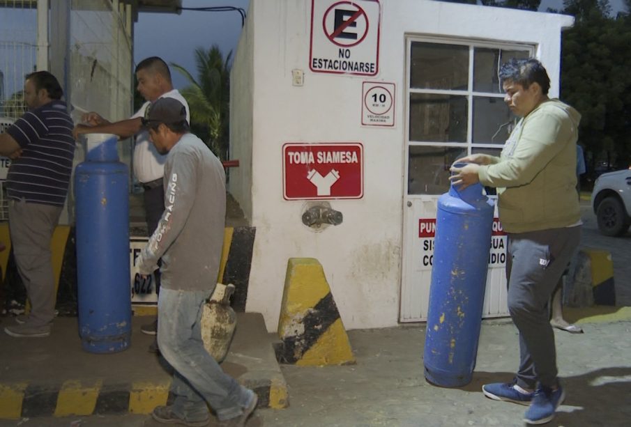 Personas en gasera cargando gas