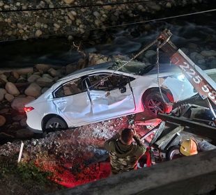 Vehículo volcado en la rivera del Cuale