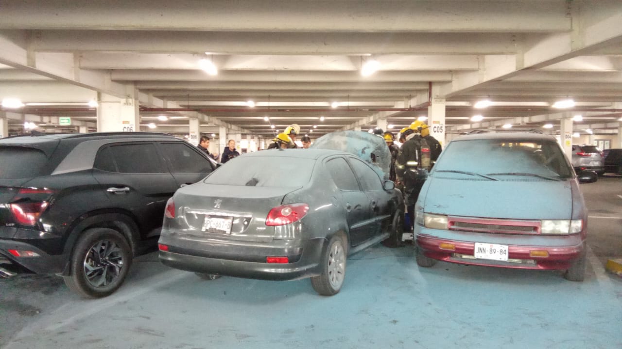 Automóvil calcinado en estacionamiento de supermercado