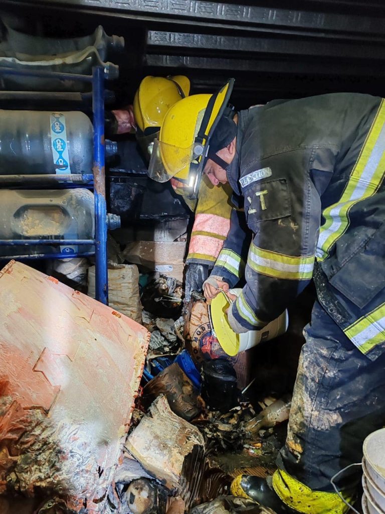 Bomberoros sofocando fuego en tienda de conveniencia