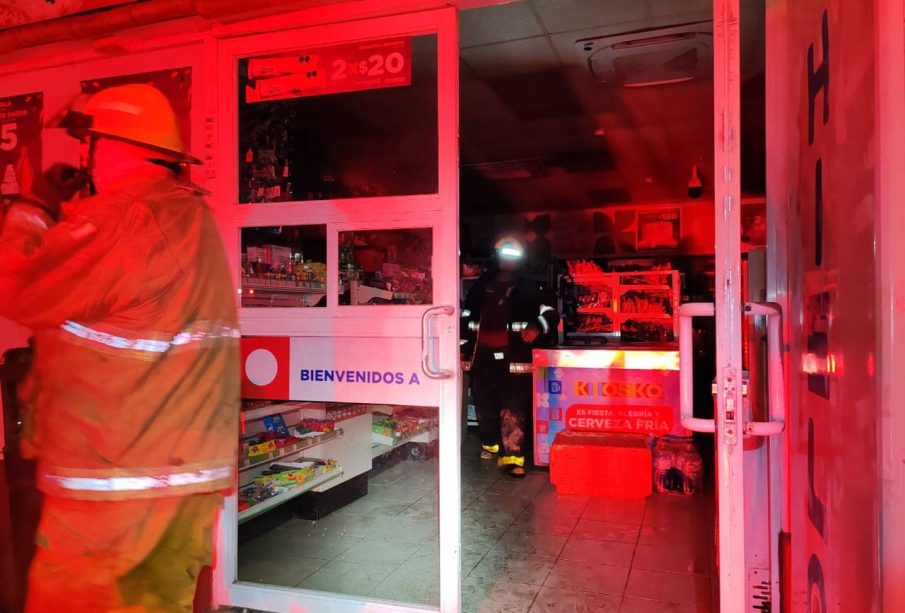 Bomberos en tienda de conveniencia incendiada