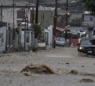 Carro transitando calle en plena lluvia en Tijuana