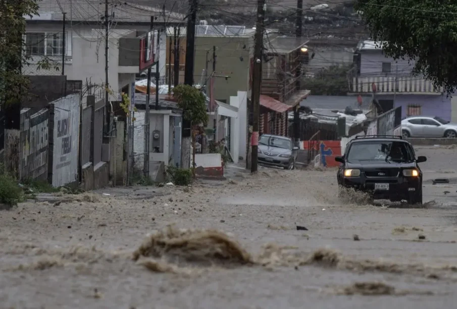 Carro transitando calle en plena lluvia en Tijuana