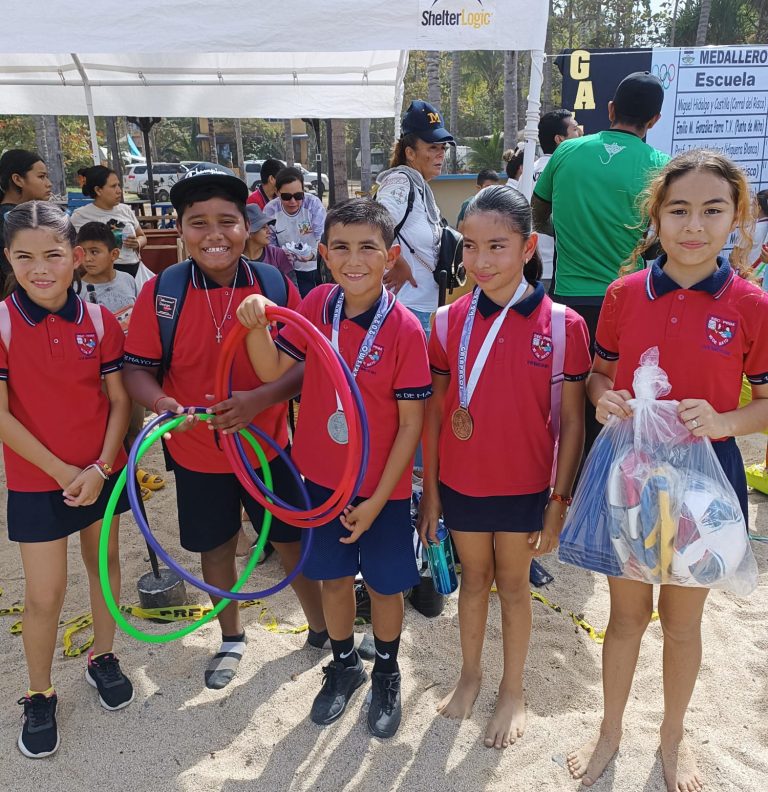 Niños con medallas y regalos tras evento atlético en la playa