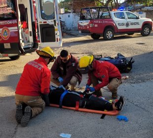 Paramédicos atendiendo a motociclista tras accidente