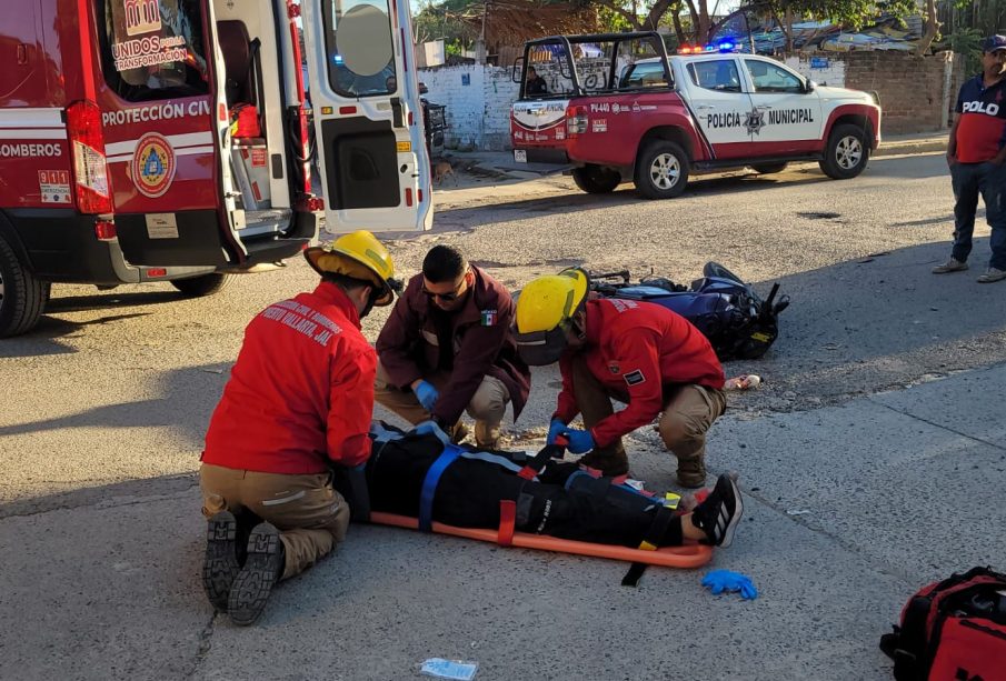 Paramédicos atendiendo a motociclista tras accidente