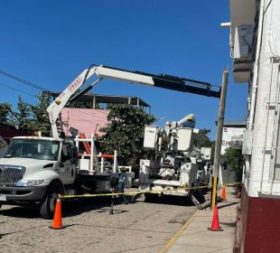 Trabajadores de la CFE reparando poste