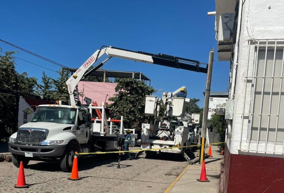 Trabajadores de la CFE reparando poste