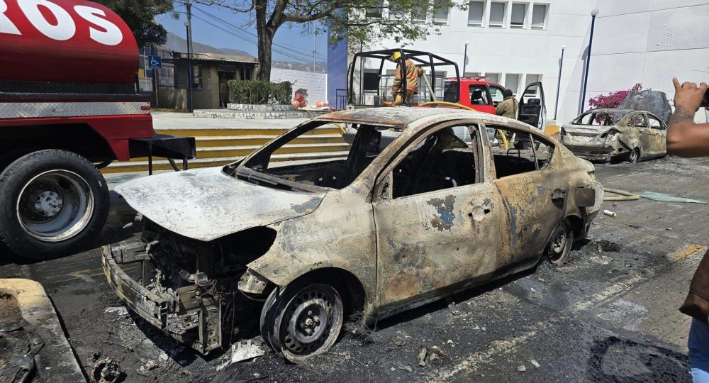 Bomberos atendiendo autos quemados por normalistas