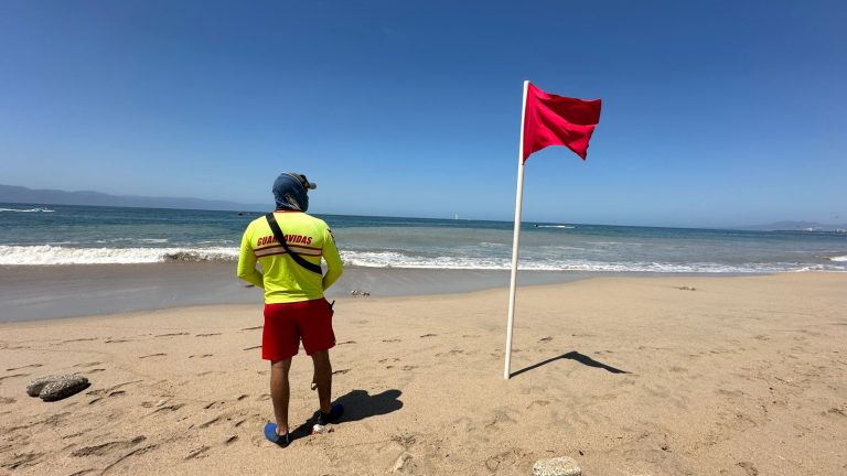 Guardavida junto a bandera roja colocada en playa