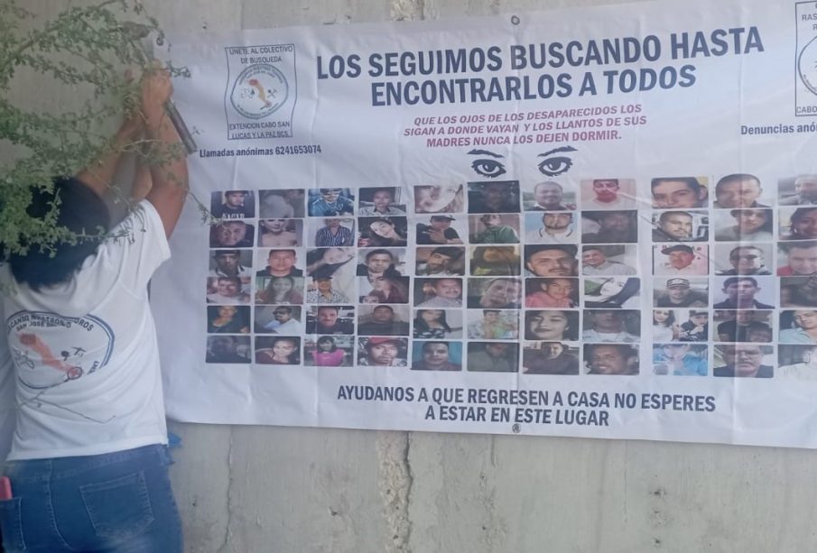 Madre buscadora colocando manta de desaparecidos