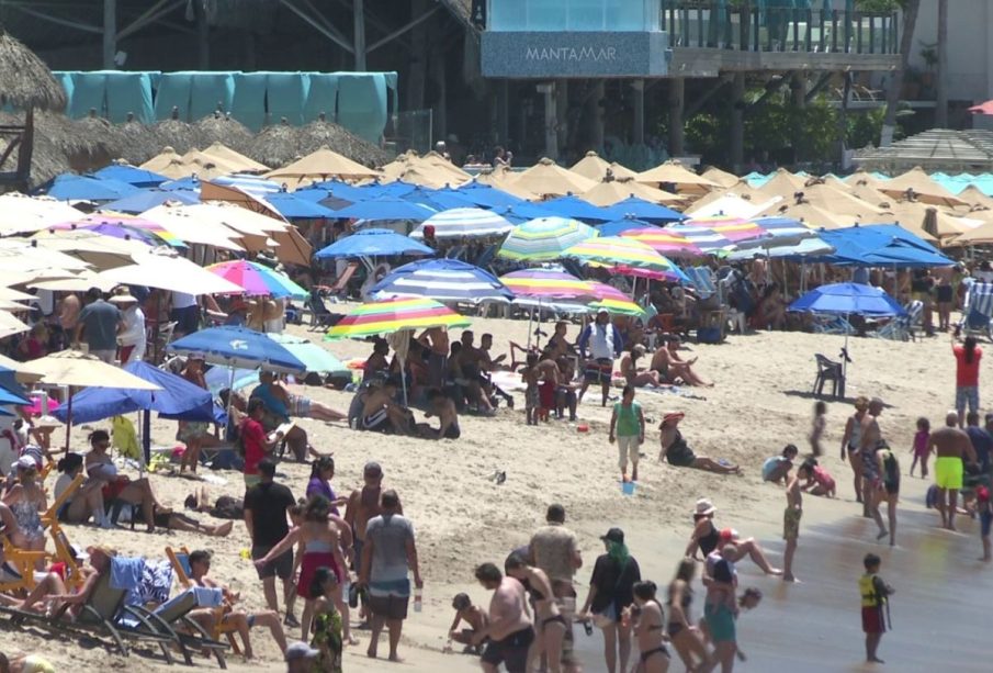 Turistas bajo sombrillas en la playa